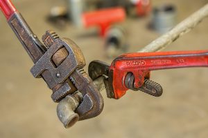 Two wrenches twisting a pipe commercial plumbing