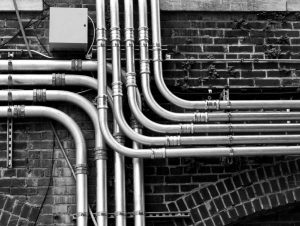 commercial pipes along a brick wall